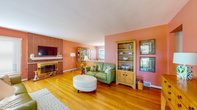 living room featuring wood-type flooring and a brick fireplace