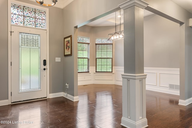 foyer featuring dark wood-type flooring and decorative columns