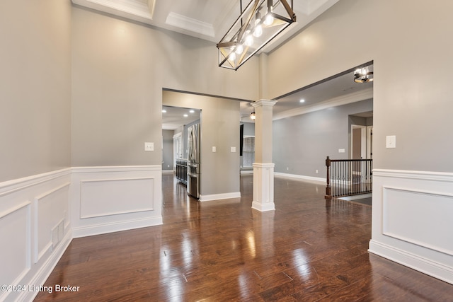 interior space with ornate columns, dark wood-type flooring, and ornamental molding