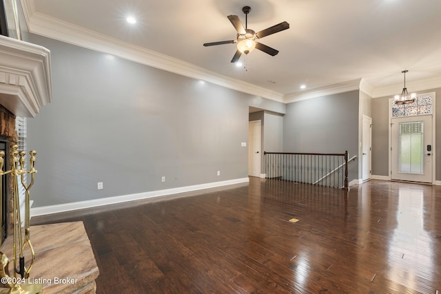 unfurnished living room featuring ceiling fan with notable chandelier, dark wood-type flooring, and crown molding