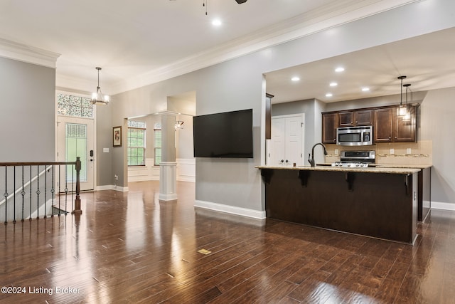 kitchen featuring kitchen peninsula, dark hardwood / wood-style flooring, a kitchen breakfast bar, and appliances with stainless steel finishes