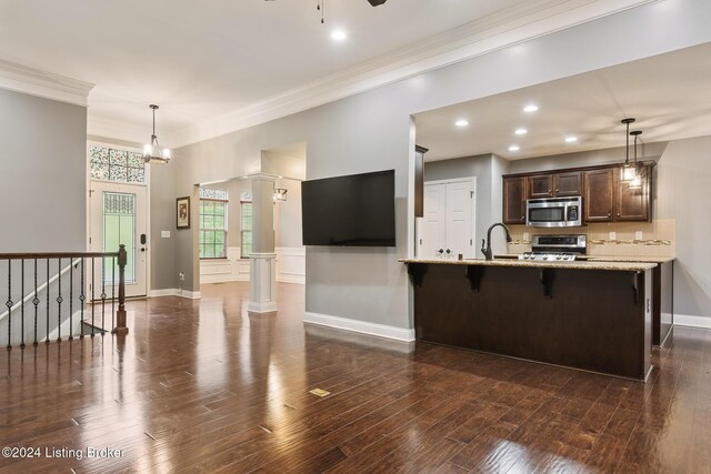 304 Hidden Falls Dr, Mt Washington, KY 40047 - kitchen with stainless steel microwave, range, dark brown cabinetry, a breakfast bar area, and a peninsula