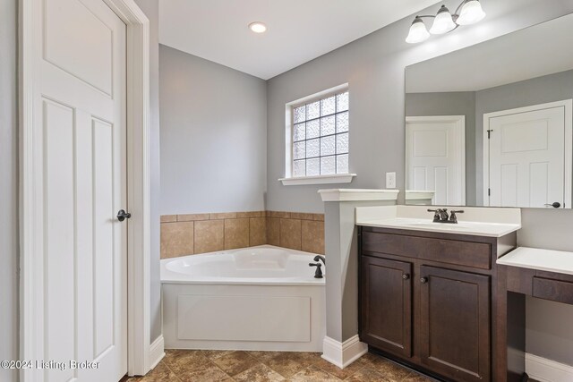 304 Hidden Falls Dr, Mt Washington, KY 40047 - bathroom featuring a garden tub, vanity, and baseboards