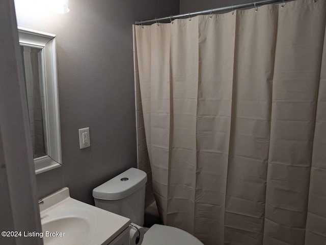 bathroom featuring walk in shower, vanity, and toilet