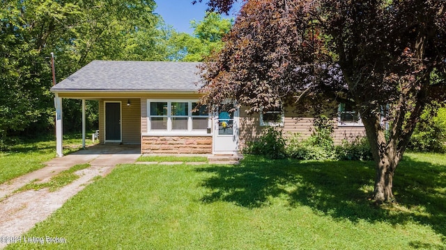 view of front of home with a front yard and a carport