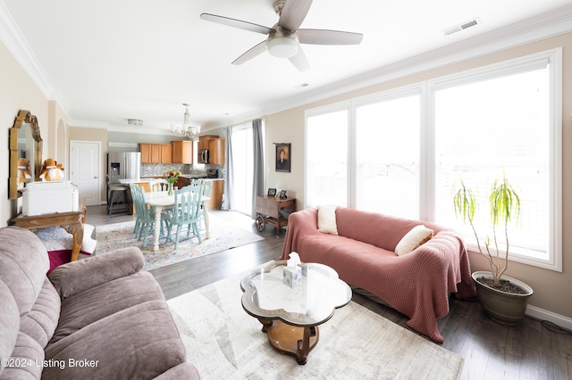 living room with hardwood / wood-style flooring, ceiling fan with notable chandelier, and crown molding