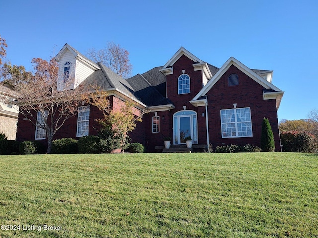 traditional-style house with a front lawn and brick siding