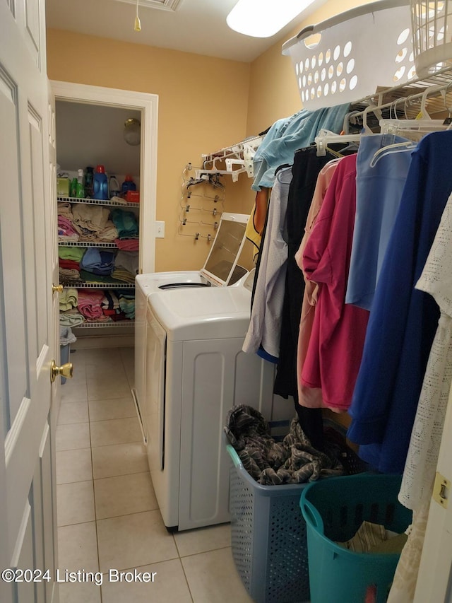 laundry area featuring washing machine and dryer and light tile patterned floors