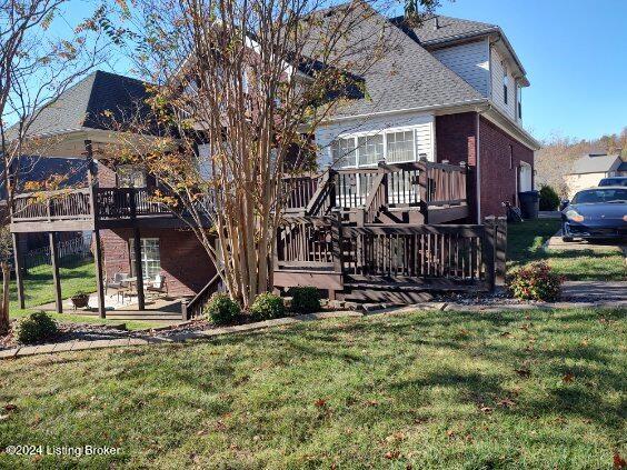 back of house featuring a deck and a yard