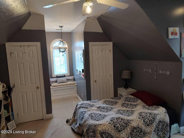 bedroom with carpet flooring, lofted ceiling, and ceiling fan with notable chandelier