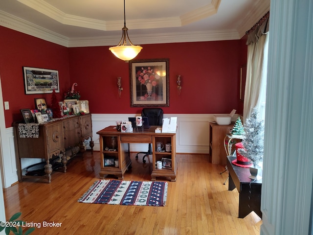 dining area with a raised ceiling, light hardwood / wood-style flooring, and crown molding