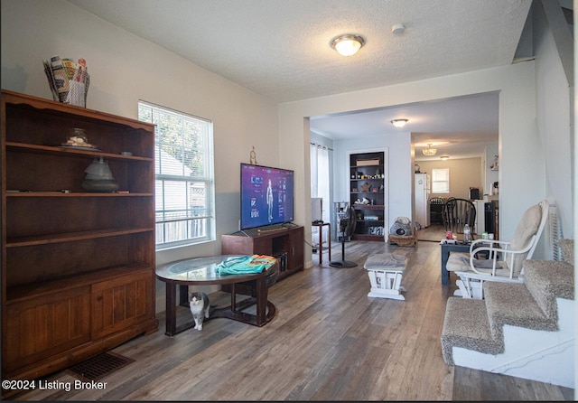 living room with hardwood / wood-style floors and a textured ceiling