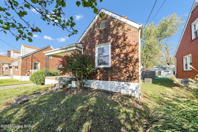 view of front of property with a front yard and central AC