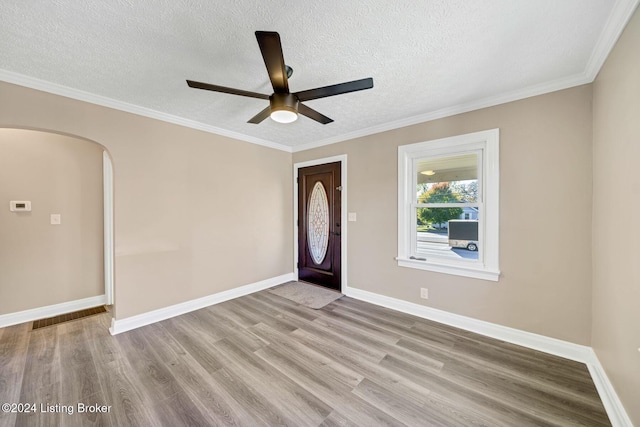 entrance foyer with ornamental molding, light hardwood / wood-style floors, and a textured ceiling