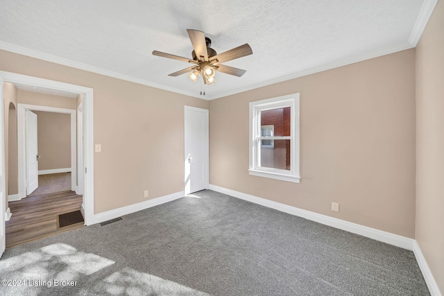 unfurnished bedroom with ceiling fan, a textured ceiling, dark carpet, and ornamental molding