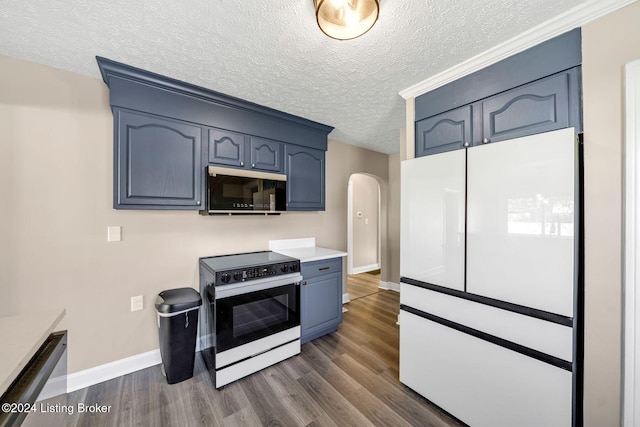 kitchen with a textured ceiling, range, blue cabinets, dark wood-type flooring, and white refrigerator