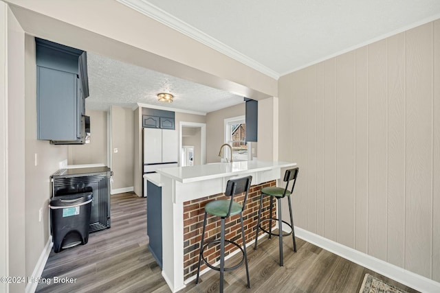 kitchen with dark hardwood / wood-style flooring, white fridge, kitchen peninsula, and a kitchen breakfast bar