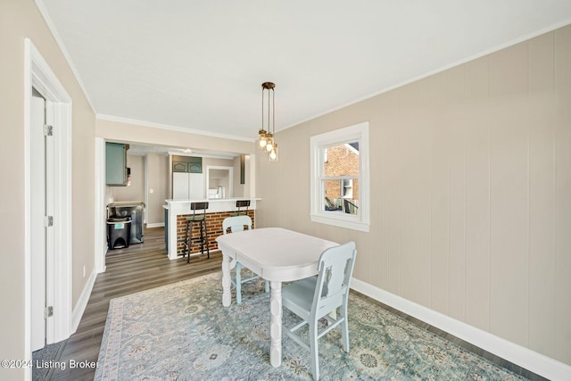 dining space with dark hardwood / wood-style floors and crown molding