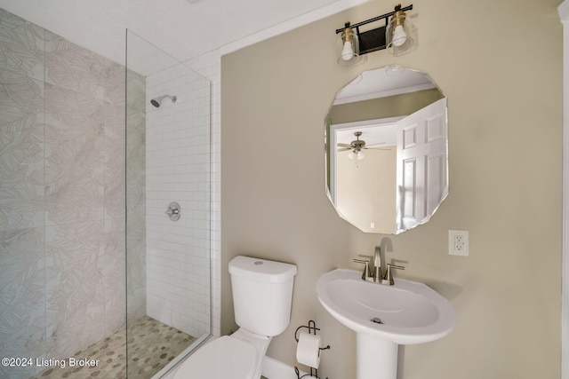 bathroom featuring toilet, ceiling fan, sink, and tiled shower