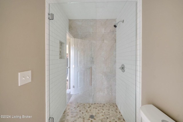 bathroom featuring walk in shower and toilet