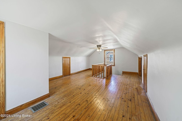 additional living space with light hardwood / wood-style floors and vaulted ceiling