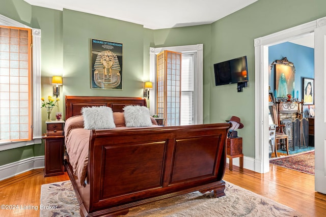 bedroom featuring a fireplace and light hardwood / wood-style flooring