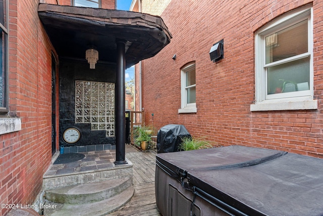 view of patio / terrace featuring a hot tub, area for grilling, and a wooden deck