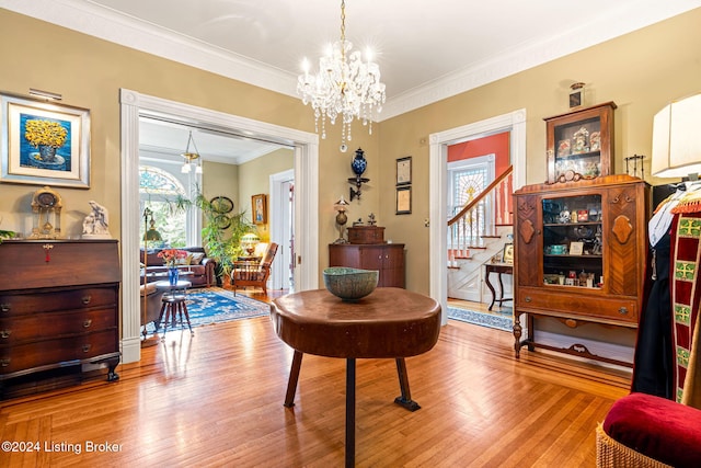 misc room with light hardwood / wood-style floors, crown molding, and a notable chandelier