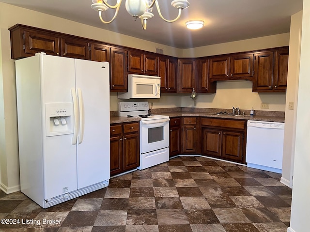 kitchen with white appliances, sink, and a notable chandelier