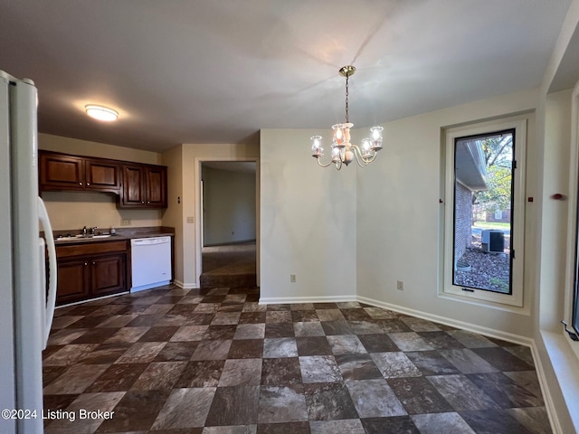 kitchen featuring hanging light fixtures, white appliances, sink, and a notable chandelier