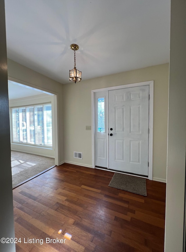 foyer entrance featuring dark hardwood / wood-style floors, a healthy amount of sunlight, and a chandelier