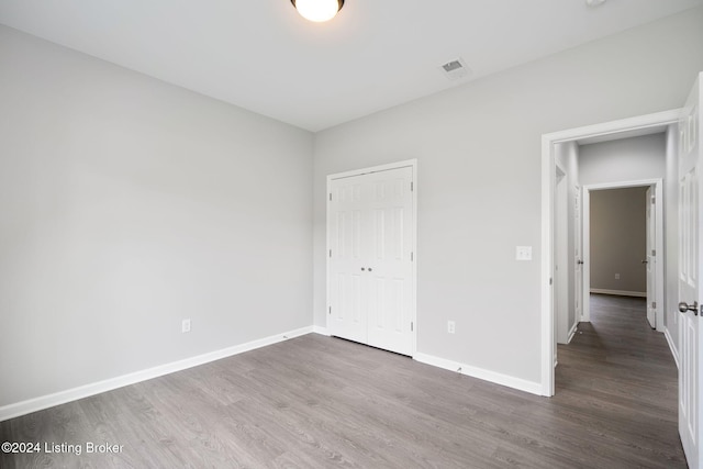 unfurnished bedroom with a closet and hardwood / wood-style floors