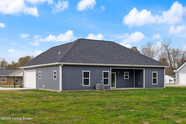 rear view of house with central AC, a lawn, covered porch, and a garage