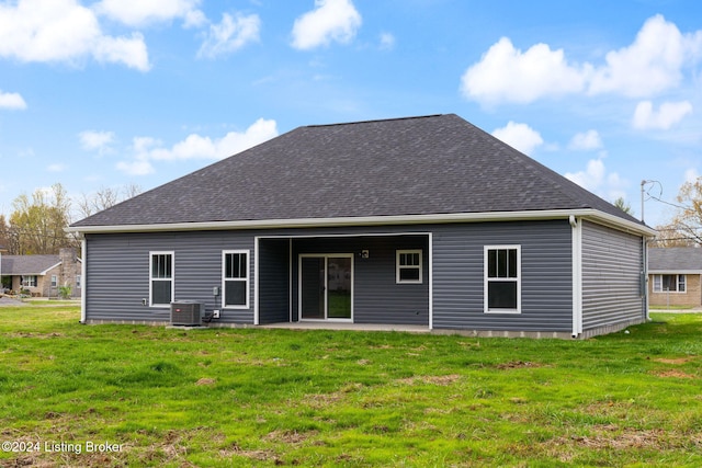 rear view of house with a lawn and central AC unit