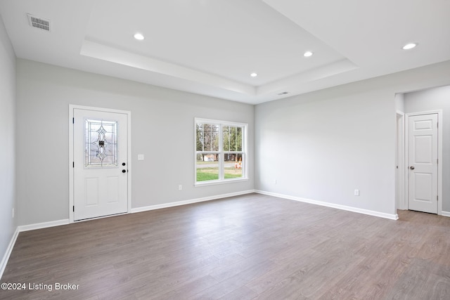 interior space featuring wood-type flooring and a raised ceiling