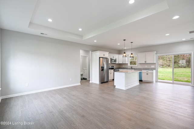 kitchen featuring stainless steel appliances, a kitchen island, pendant lighting, light hardwood / wood-style flooring, and white cabinetry