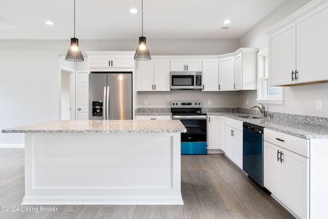 kitchen featuring white cabinets, stainless steel appliances, sink, and a kitchen island