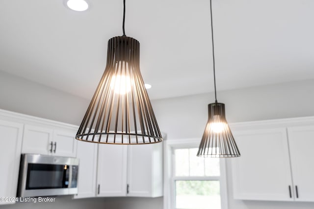 interior details with white cabinets and hanging light fixtures