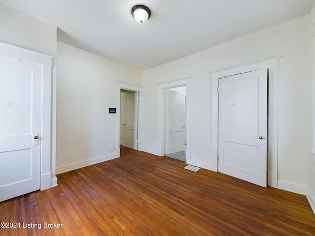 unfurnished bedroom with dark wood-type flooring