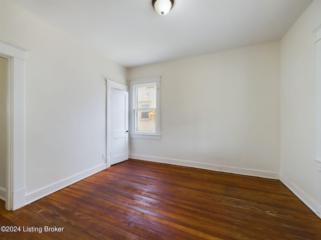 spare room with dark wood-type flooring