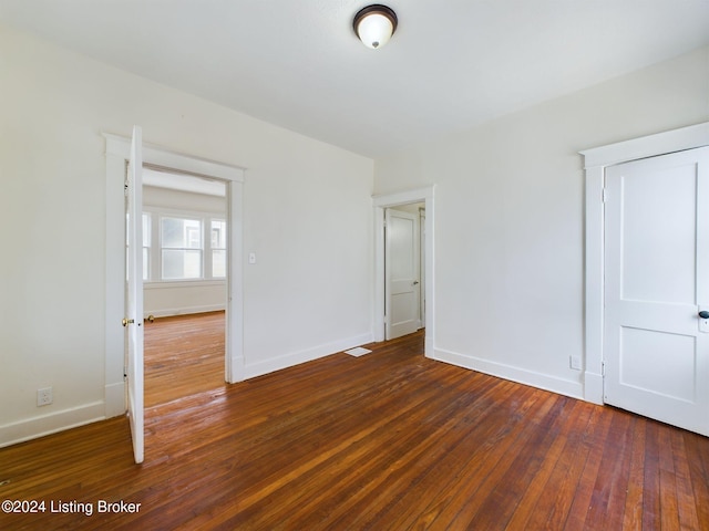 unfurnished bedroom with dark hardwood / wood-style flooring