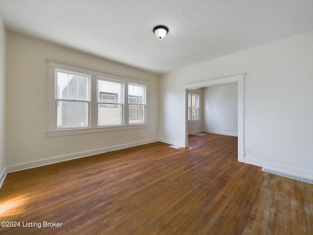 unfurnished room featuring a textured ceiling and dark wood-type flooring