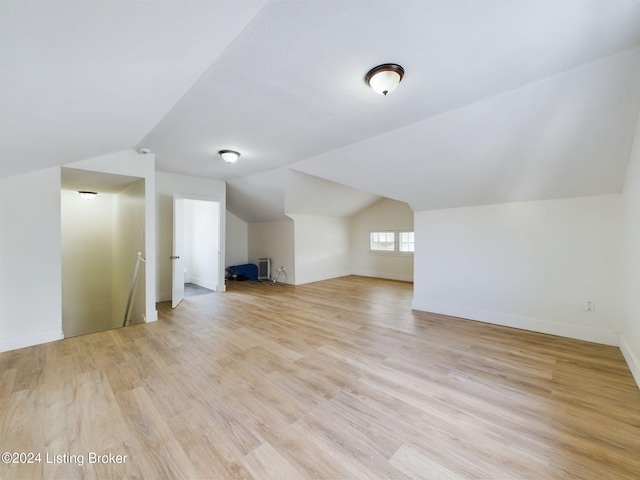 additional living space featuring light hardwood / wood-style flooring and vaulted ceiling