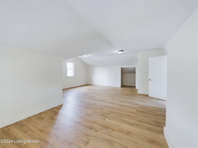 additional living space with lofted ceiling and light wood-type flooring