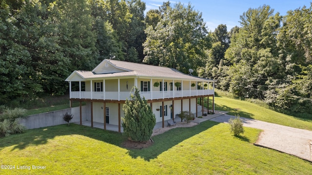 rear view of property featuring a lawn and a patio