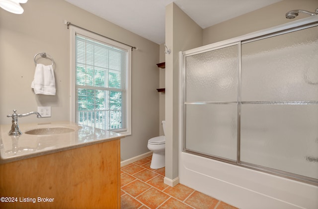 full bathroom featuring shower / bath combination with glass door, tile patterned floors, toilet, and vanity