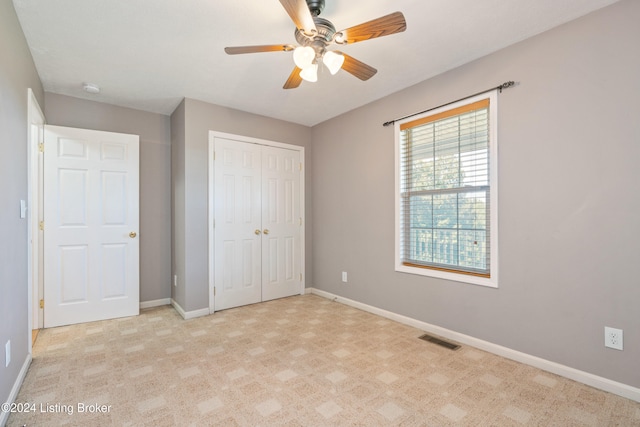 unfurnished bedroom with a closet, light carpet, and ceiling fan