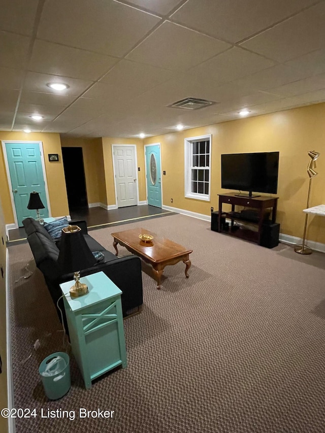 living room with carpet flooring and a paneled ceiling