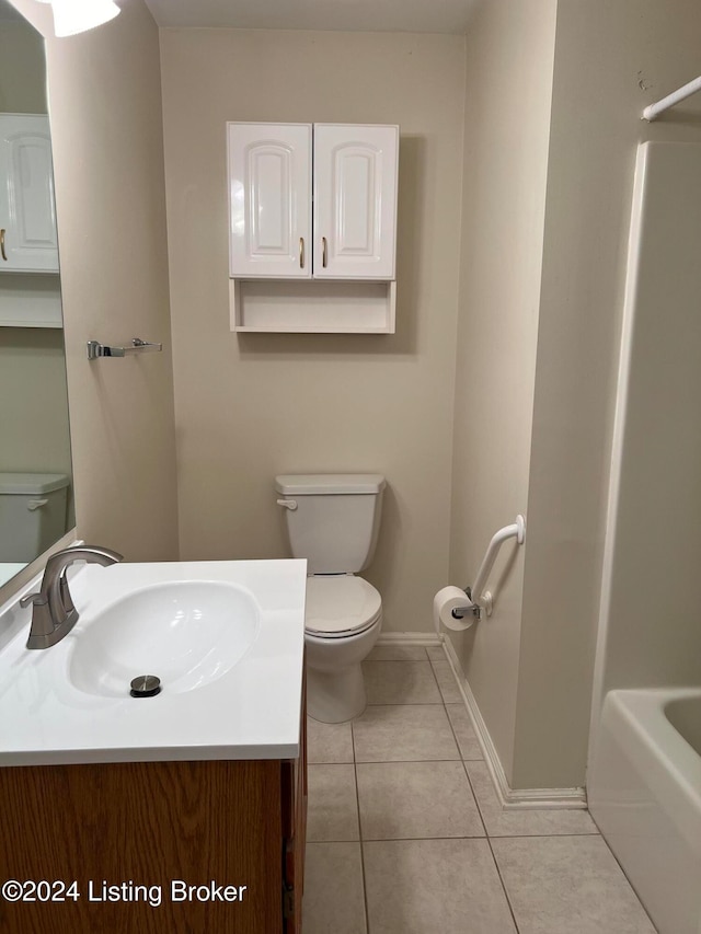 bathroom featuring vanity, tile patterned flooring, toilet, and a washtub