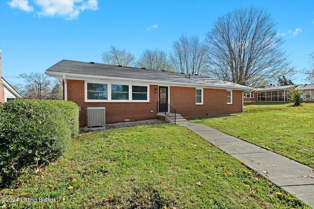 view of front of property with central air condition unit and a front yard